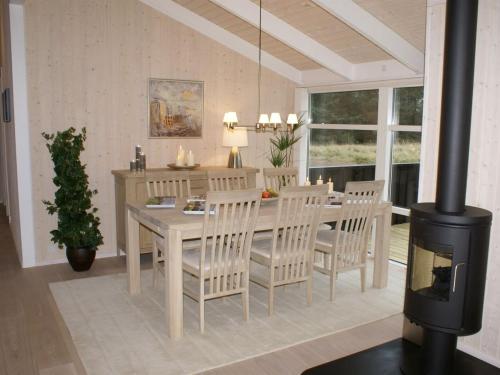 a dining room with a table and chairs and a fireplace at Holiday Home Asol - 650m from the sea by Interhome in Løkken