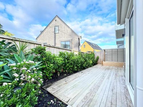 a wooden walkway in front of a house at Family Oasis 3BR vs Backyard Near Beach in Torbay in Auckland