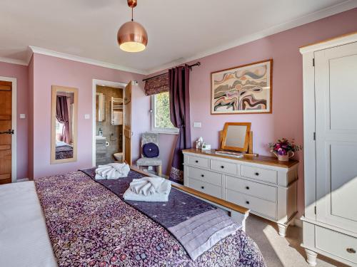 a bedroom with two beds and a dresser and a mirror at 5 Bed in Newton-in-Cartmel 95876 in High Newton