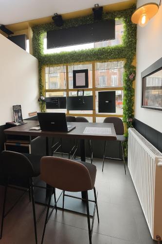 a room with a table and chairs with a green wall at Hôtel Le Paris Brest in Lens