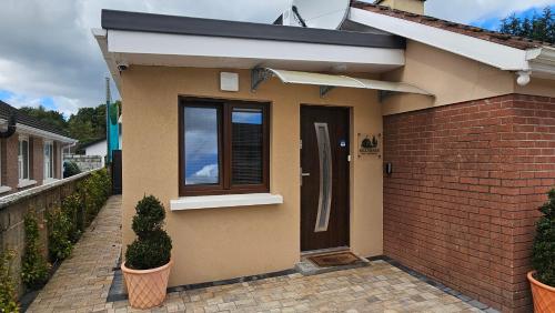 a small house with a door and a brick wall at Killarney Cosy Hideaway in Killarney