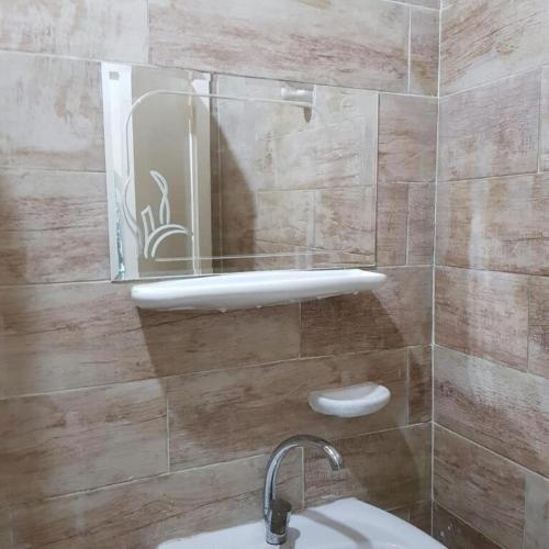 a bathroom with a sink and a mirror on the wall at Sweet Home Hostel - ممنوع للبنات فى الوقت الحالى in Hurghada