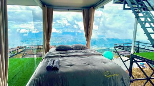 a bedroom with a bed in front of a large window at Memory เมมโมรี่ ภูทับเบิก in Ban Maeo Thap Boek