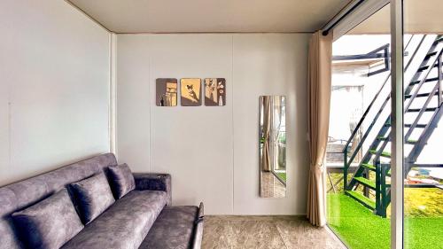 a living room with a couch and a staircase at Memory เมมโมรี่ ภูทับเบิก in Ban Maeo Thap Boek