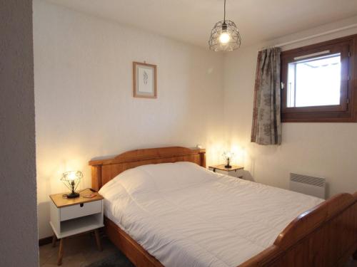 ein Schlafzimmer mit einem Bett und zwei Tischen mit Lampen in der Unterkunft Appartement Central 6 Pers, Parking, Ascenseur, Proche Pistes et Commerces - FR-1-572-22 in Les Carroz d'Araches