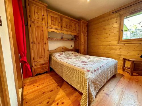 ein Schlafzimmer mit einem Bett in einem Holzzimmer in der Unterkunft 3 pièces, 6 pers, animaux admis, parking, vue sur piscine - FR-1-572-5 in Arâches-la-Frasse