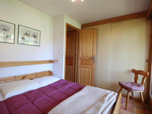 ein Schlafzimmer mit einem großen Bett und einem Stuhl in der Unterkunft Duplex lumineux 3 pièces, 7 pers, 3 balcons, proche pistes et commerces, parking, ski bus - FR-1-572-72 in Arâches-la-Frasse