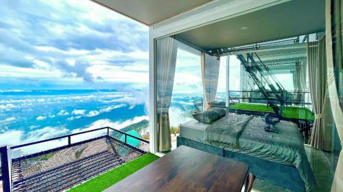 a bedroom with a bed and a view of the ocean at Memory เมมโมรี่ ภูทับเบิก in Ban Maeo Thap Boek