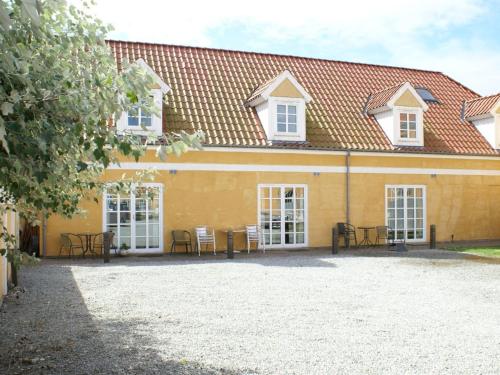 a yellow building with tables and chairs in front of it at Apartment Swarthovde - 300m from the sea by Interhome in Løkken