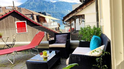 a balcony with chairs and couches on a building at Organic BnB Froschkoenig Rigi Burggeist in Gersau