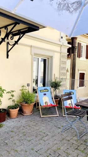 two lawn chairs sitting under an umbrella on a patio at Organic BnB Froschkoenig Rigi Burggeist in Gersau