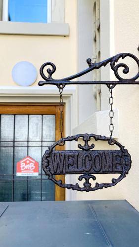 a sign that says welcome hanging from a chain at Organic BnB Froschkoenig Rigi Burggeist in Gersau