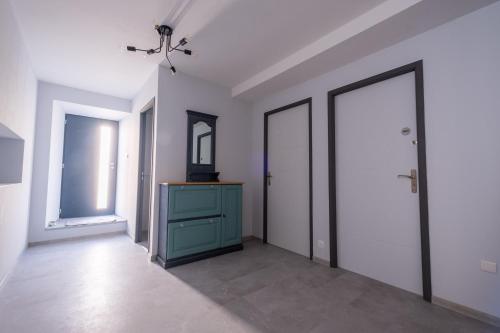 an empty room with a blue dresser and a mirror at Gite de l'escapade in Rieutort