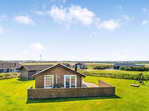 a house on a green lawn with houses in the background at Holiday Home Anya - 650m from the sea by Interhome in Løkken