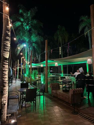 a patio with tables and chairs at night at Grand Carimã Resort & Convention Center in Foz do Iguaçu