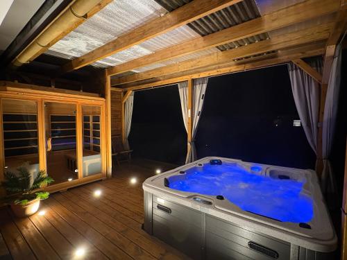 a large blue tub in a room with a window at La Kaz 57 - Maison avec jacuzzi et sauna - La Réunion in La Plaine des Palmistes