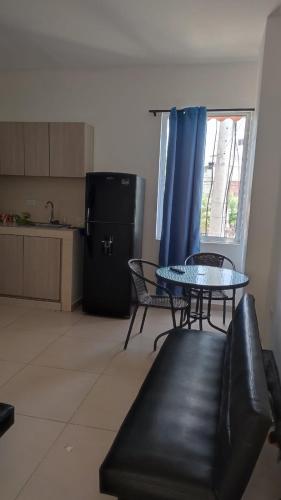 a living room with a black couch and a table at Apartahotel Vista hermosa Inn in Santa Marta