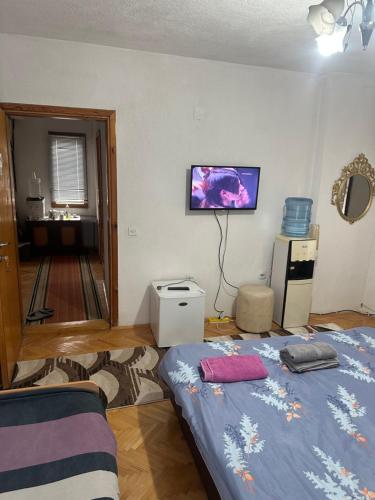 a bedroom with a bed and a tv on the wall at Rooms Struga in Struga