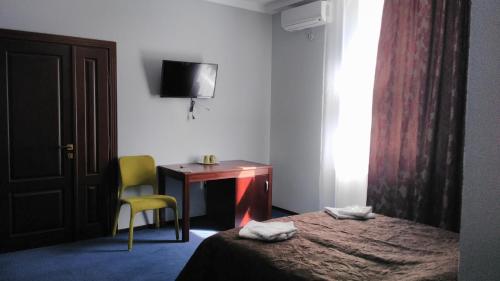 a bedroom with a bed and a desk and a chair at City Club European in Chernivtsi