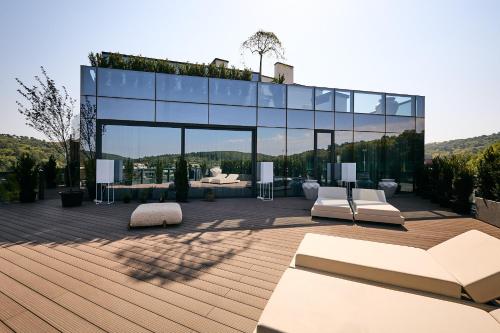 a glass house with white furniture on a deck at Emily Resort in Lviv