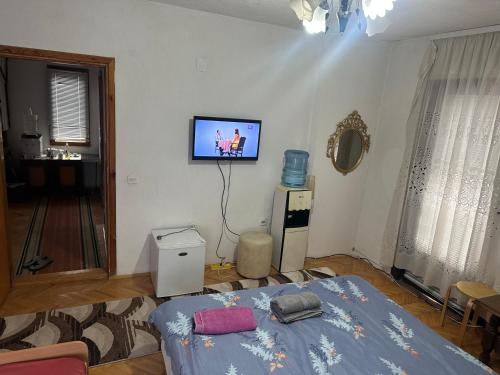 a room with a bed and a tv on the wall at Rooms Struga in Struga