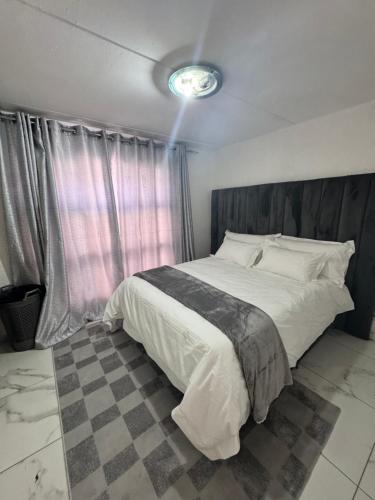 a bedroom with a large bed with a wooden headboard at Luxe spot in Johannesburg