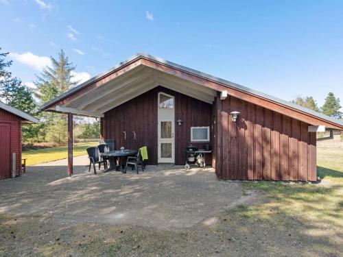 a large wooden building with a table and chairs at Holiday Home Herwarth - 3-3km from the sea by Interhome in Blokhus