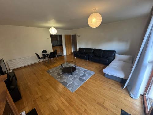 a living room with a couch and a table at Spacious 2-Bed Apartment Opposite Santry Park & 10 Min Away from Airport in Dublin