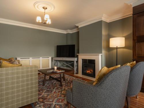 a living room with a couch and a fireplace at Lough Erne Resort in Enniskillen
