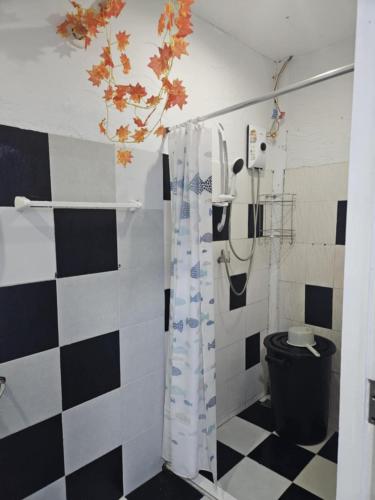 a bathroom with a shower with a black and white checkered floor at Af พลูวิลล่า in Na Jomtien