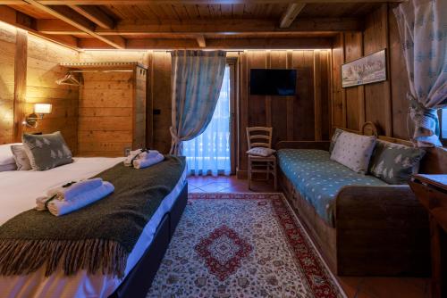a hotel room with two beds and a couch at B&B Nonna Ila in Courmayeur