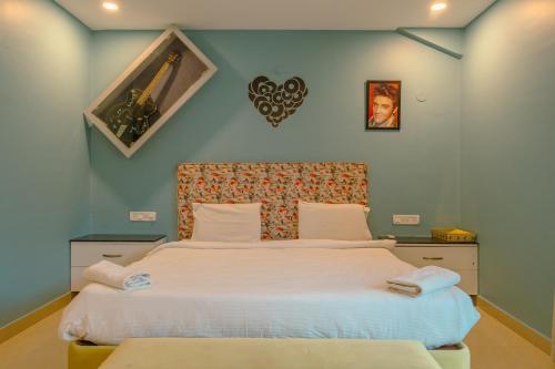 a bedroom with a large bed with white sheets at 2 bedroom perfect stay villas in Anjuna