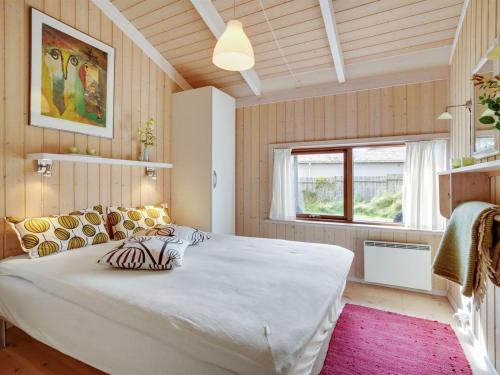 a bedroom with a large white bed and a window at Holiday Home Friderike - 200m from the sea by Interhome in Blokhus
