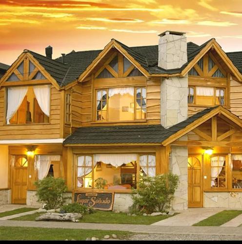 a large wooden house with a sign in front of it at Cabañas frente al lago vista al jardin in San Martín de los Andes