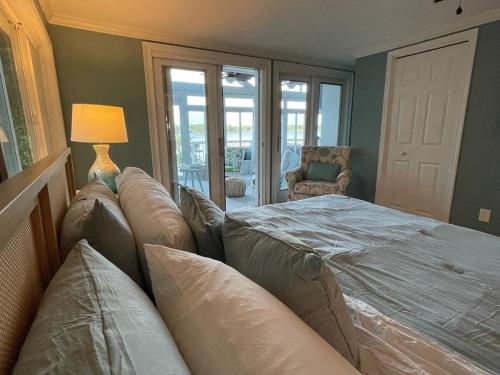 a bedroom with a bed with a couch and a lamp at Palms in Paradise 2 Docks & Steps into Lake Murray in Chapin