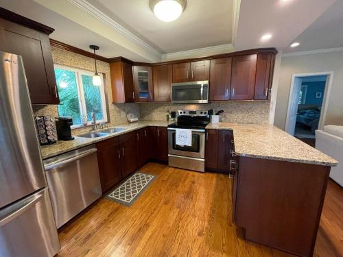 a kitchen with wooden cabinets and stainless steel appliances at Palms in Paradise 2 Docks & Steps into Lake Murray in Chapin