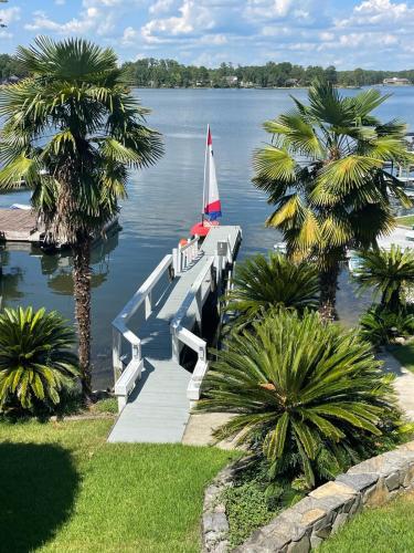 a boat on a dock on a lake with palm trees at Palms in Paradise 2 Docks & Steps into Lake Murray in Chapin