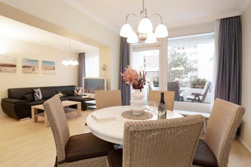 a dining room and living room with a table and chairs at Tannenburg Wohnung 205 in Grömitz