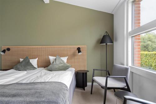 a bedroom with a bed and a chair and a window at Best Western Hotel Hillerød in Hillerød