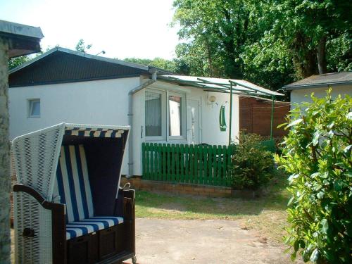 a yard with a chair in front of a house at Ferienbungalow Fleesensee in Malchow