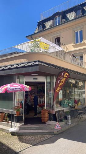 a store with an umbrella in front of a building at Organic BnB Froschkoenig Chaiserstock in Gersau