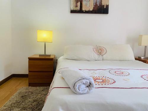 una camera da letto con un letto e un asciugamano sopra di Residencial Paraíso a Luanda