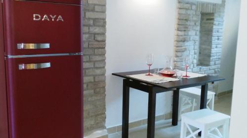 a table with wine glasses and a red refrigerator at Lally House in Pesaro