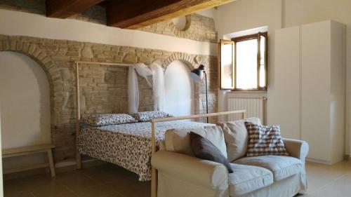 a bedroom with a bed and a couch and a chair at Lally House in Pesaro