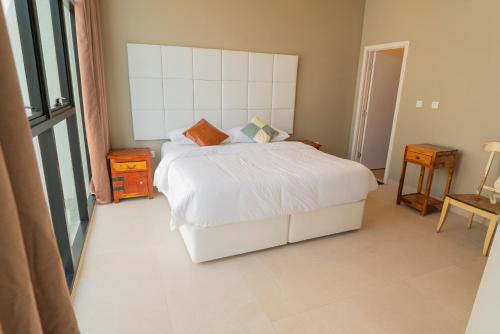 a bedroom with a white bed and a window at Dar 66 Digdagga Pool Chalet with Jacuzzi in Ras al Khaimah