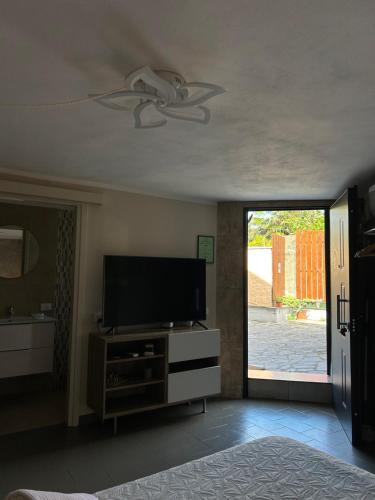 a living room with a television and a sliding glass door at Villa Luce in Vairano