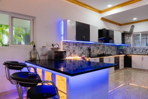 eine Küche mit einer blauen Theke und Stühlen in der Unterkunft Mayns Executive room -blue in Chennai