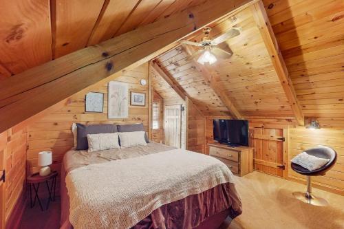 a bedroom with a bed in a wooden cabin at Sunset Mountain Cabin in Ellijay