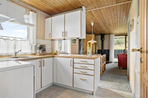 a kitchen with white cabinets and a dining room at LN1781-Hjorring-Vadehavsvej-14 in Hjørring