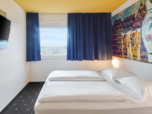 Ένα ή περισσότερα κρεβάτια σε δωμάτιο στο B&B Hotel Frankfurt-Nord